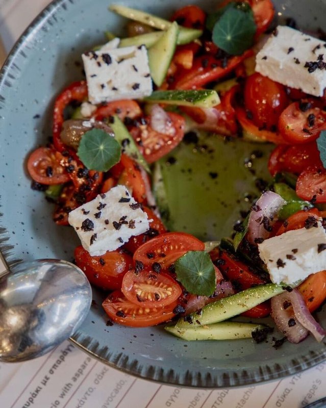Greek salad with cherry tomatoes, cucumber, peppers, and olives