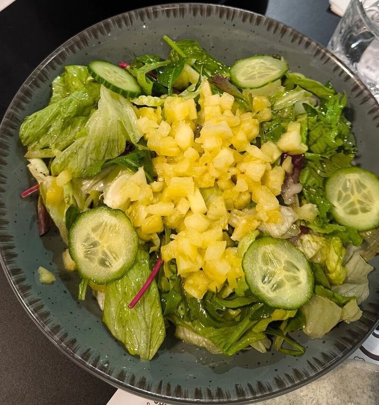 Green salad with goat cheese, pineapple, cashew crumble, and a refreshing honey-calamansi dressing